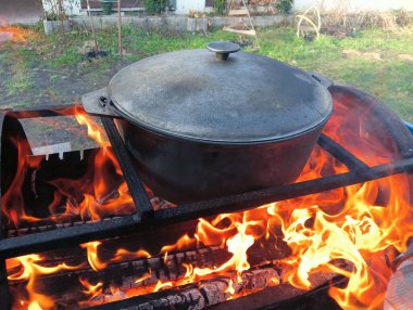 pot on fire. kettle on fire. Cooking on an Open Fire in a Tourist Pot. Cooking at the stake in a tourist bowler hat. Hiking. Tourist pot at bonfire. Large pot on a campfire on a camping trip