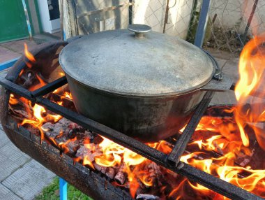 pot on fire. kettle on fire. Cooking on an Open Fire in a Tourist Pot. Cooking at the stake in a tourist bowler hat. Hiking. Tourist pot at bonfire. Large pot on a campfire on a camping trip