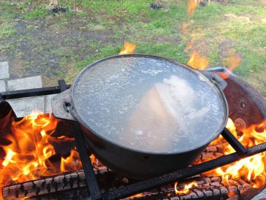 pot on fire. kettle on fire. Cooking on an Open Fire in a Tourist Pot. Cooking at the stake in a tourist bowler hat. Hiking. Tourist pot at bonfire. Large pot on a campfire on a camping trip
