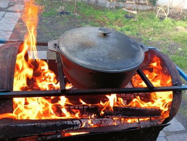 pot on fire. kettle on fire. Cooking on an Open Fire in a Tourist Pot. Cooking at the stake in a tourist bowler hat. Hiking. Tourist pot at bonfire. Large pot on a campfire on a camping trip