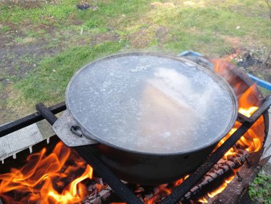 pot on fire. kettle on fire. Cooking on an Open Fire in a Tourist Pot. Cooking at the stake in a tourist bowler hat. Hiking. Tourist pot at bonfire. Large pot on a campfire on a camping trip