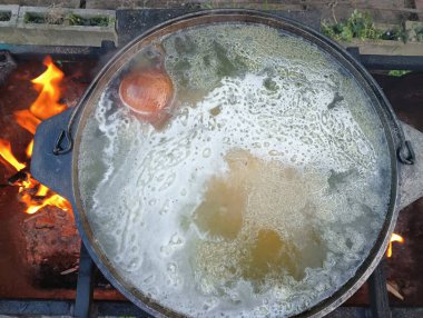 pot on fire. kettle on fire. Cooking on an Open Fire in a Tourist Pot. Cooking at the stake in a tourist bowler hat. Hiking. Tourist pot at bonfire. Large pot on a campfire on a camping trip