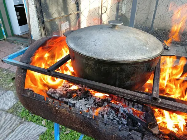 pot on fire. kettle on fire. Cooking on an Open Fire in a Tourist Pot. Cooking at the stake in a tourist bowler hat. Hiking. Tourist pot at bonfire. Large pot on a campfire on a camping trip