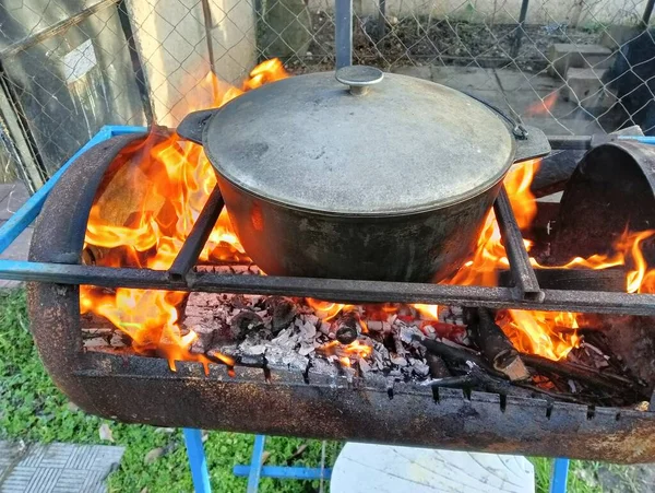 pot on fire. kettle on fire. Cooking on an Open Fire in a Tourist Pot. Cooking at the stake in a tourist bowler hat. Hiking. Tourist pot at bonfire. Large pot on a campfire on a camping trip