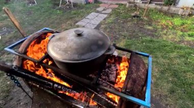 pot on fire. kettle on fire. Cooking on an Open Fire in a Tourist Pot. Cooking at the stake in a tourist bowler hat. Hiking. Tourist pot at bonfire. Large pot on a campfire on a camping trip