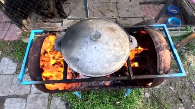 pot on fire. kettle on fire. Cooking on an Open Fire in a Tourist Pot. Cooking at the stake in a tourist bowler hat. Hiking. Tourist pot at bonfire. Large pot on a campfire on a camping trip