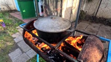 pot on fire. kettle on fire. Cooking on an Open Fire in a Tourist Pot. Cooking at the stake in a tourist bowler hat. Hiking. Tourist pot at bonfire. Large pot on a campfire on a camping trip