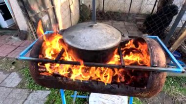 pot on fire. kettle on fire. Cooking on an Open Fire in a Tourist Pot. Cooking at the stake in a tourist bowler hat. Hiking. Tourist pot at bonfire. Large pot on a campfire on a camping trip