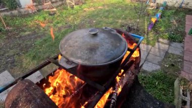 pot on fire. kettle on fire. Cooking on an Open Fire in a Tourist Pot. Cooking at the stake in a tourist bowler hat. Hiking. Tourist pot at bonfire. Large pot on a campfire on a camping trip