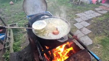 pot on fire. kettle on fire. Cooking on an Open Fire in a Tourist Pot. Cooking at the stake in a tourist bowler hat. Hiking. Tourist pot at bonfire. Large pot on a campfire on a camping trip