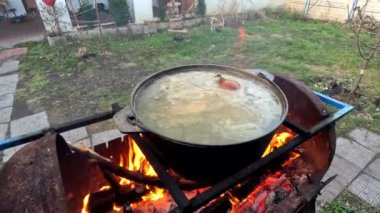 pot on fire. kettle on fire. Cooking on an Open Fire in a Tourist Pot. Cooking at the stake in a tourist bowler hat. Hiking. Tourist pot at bonfire. Large pot on a campfire on a camping trip