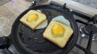 scrambled eggs in bread. An egg and sausage pieces fried in the middle of a slice of toast, also known as an egg in a basket. Close-up of a meal made from eggs in bread. Homemade breakfast idea.