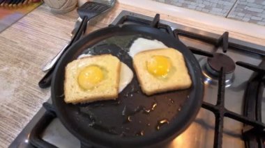 scrambled eggs in bread. An egg and sausage pieces fried in the middle of a slice of toast, also known as an egg in a basket. Close-up of a meal made from eggs in bread. Homemade breakfast idea.