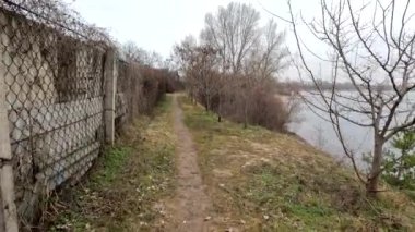 cloudy landscape on the banks of the river. natural landscape with water. walk by the water. Narrow path over a cliff. Water break. Strong wind near the river. Winter beach. Without people. Ukrainian nature. Ukraine.