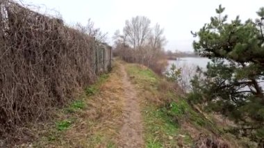 cloudy landscape on the banks of the river. natural landscape with water. walk by the water. Narrow path over a cliff. Water break. Strong wind near the river. Winter beach. Without people. Ukrainian nature. Ukraine.