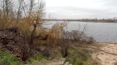 cloudy landscape on the banks of the river. natural landscape with water. walk by the water. Narrow path over a cliff. Water break. Strong wind near the river. Winter beach. Without people. Ukrainian nature. Ukraine.