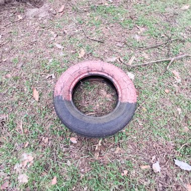 old tires. wheels are dug into the ground. painted tires. Old Retro Kid's Playground With Rubber Tires In The Park. Wall Of The Old Tires On The Racing Track. Pile of waste tires.