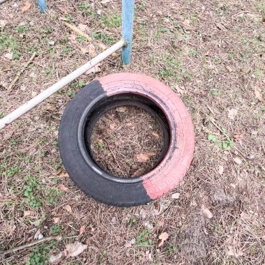 old tires. wheels are dug into the ground. painted tires. Old Retro Kid's Playground With Rubber Tires In The Park. Wall Of The Old Tires On The Racing Track. Pile of waste tires.