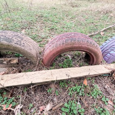 old tires. wheels are dug into the ground. painted tires. Old Retro Kid's Playground With Rubber Tires In The Park. Wall Of The Old Tires On The Racing Track. Pile of waste tires.