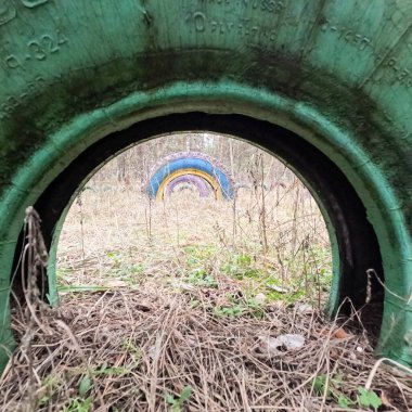 old tires. wheels are dug into the ground. painted tires. Old Retro Kid's Playground With Rubber Tires In The Park. Wall Of The Old Tires On The Racing Track. Pile of waste tires.