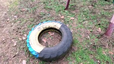 old tires. wheels are dug into the ground. painted tires. Old Retro Kid's Playground With Rubber Tires In The Park. Wall Of The Old Tires On The Racing Track. Pile of waste tires.