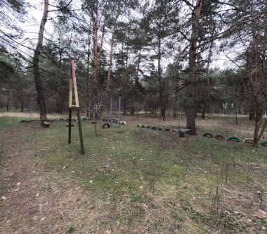 abandoned playground. Children's playground in the forest. Old Retro Kid's Playground With Rubber Tires In The Park. Surreal playground,abandoned swings in rural countryside. Ukraine.