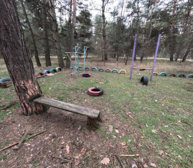 abandoned playground. Children's playground in the forest. Old Retro Kid's Playground With Rubber Tires In The Park. Surreal playground,abandoned swings in rural countryside. Ukraine.