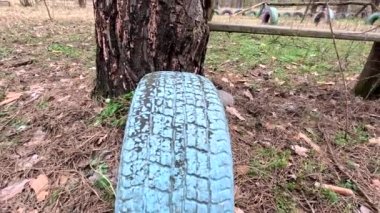 old tires. wheels are dug into the ground. painted tires. Old Retro Kid's Playground With Rubber Tires In The Park. Wall Of The Old Tires On The Racing Track. Pile of waste tires.