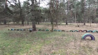 abandoned playground. Children's playground in the forest. Old Retro Kid's Playground With Rubber Tires In The Park. Surreal playground,abandoned swings in rural countryside. Ukraine.