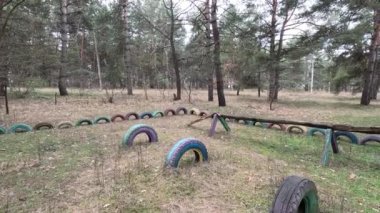 abandoned playground. Children's playground in the forest. Old Retro Kid's Playground With Rubber Tires In The Park. Surreal playground,abandoned swings in rural countryside. Ukraine.