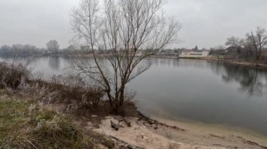 cloudy landscape on the banks of the river. high cliff above the water. Wind shakes dry reeds and makes ripples on a river with a reflection of a clouds. natural landscape with water. Dnepr River. Ukraine.