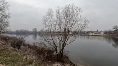 cloudy landscape on the banks of the river. high cliff above the water. Wind shakes dry reeds and makes ripples on a river with a reflection of a clouds. natural landscape with water. Dnepr River. Ukraine.