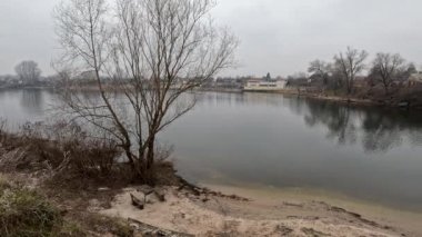 cloudy landscape on the banks of the river. high cliff above the water. Wind shakes dry reeds and makes ripples on a river with a reflection of a clouds. natural landscape with water. Dnepr River. Ukraine.