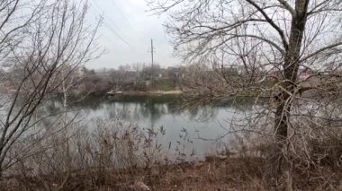 cloudy landscape on the banks of the river. high cliff above the water. Wind shakes dry reeds and makes ripples on a river with a reflection of a clouds. natural landscape with water. Dnepr River. Ukraine.