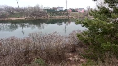 cloudy landscape on the banks of the river. high cliff above the water. Wind shakes dry reeds and makes ripples on a river with a reflection of a clouds. natural landscape with water. Dnepr River. Ukraine.