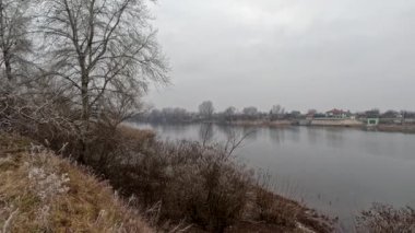 cloudy landscape on the banks of the river. high cliff above the water. Wind shakes dry reeds and makes ripples on a river with a reflection of a clouds. natural landscape with water. Dnepr River. Ukraine.