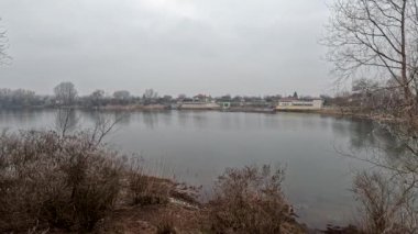 cloudy landscape on the banks of the river. high cliff above the water. Wind shakes dry reeds and makes ripples on a river with a reflection of a clouds. natural landscape with water. Dnepr River. Ukraine.