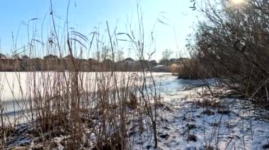 winter sunny landscape on the river bank. Beautiful scenic landscape view of a calm river flowing on a bright sunny clear blue sky. Dnieper river in winter. Ukrainian winter landscape. River bank and ice.