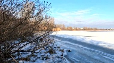 winter sunny landscape on the river bank. Beautiful scenic landscape view of a calm river flowing on a bright sunny clear blue sky. Dnieper river in winter. Ukrainian winter landscape. River bank and ice.
