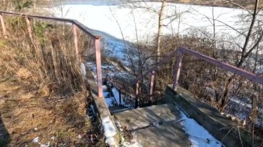concrete stairs in winter. snow on the stairs. stairs and white snow. Steps in the snow at entrance to the building in winter, slippery stairs. Old concrete staircase on the banks of the Dnieper river
