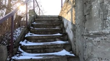 concrete stairs in winter. snow on the stairs. stairs and white snow. Steps in the snow at entrance to the building in winter, slippery stairs. Old concrete staircase on the banks of the Dnieper river