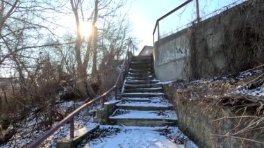 concrete stairs in winter. snow on the stairs. stairs and white snow. Steps in the snow at entrance to the building in winter, slippery stairs. Old concrete staircase on the banks of the Dnieper river