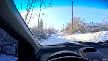 the driver is driving. from the first person. winter road. travel in winter. inside the car. dirty windshield. the driver is holding the steering wheel. sunny day and transport. transport on the road in winter.