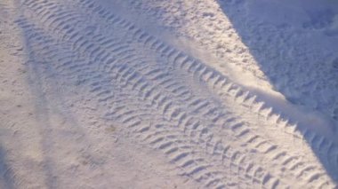 tire tracks in the snow. frozen tire tires in ice. frozen tire tracks. Car tracks on the snow at a frozen lake in Finland, aerial shot. Treads and footprints in snow, city street covered in snow.