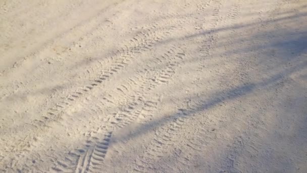 雪の中のタイヤ痕 氷の中の冷凍タイヤ 冷凍タイヤトラック フィンランドの凍った湖で雪の上の車のトラック 空中撮影 雪の中を歩くと足跡 雪に覆われた街の通り — ストック動画