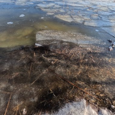 clear ice on the river. ice texture. the ice is melting. spring thaw. frozen water. air and water.
