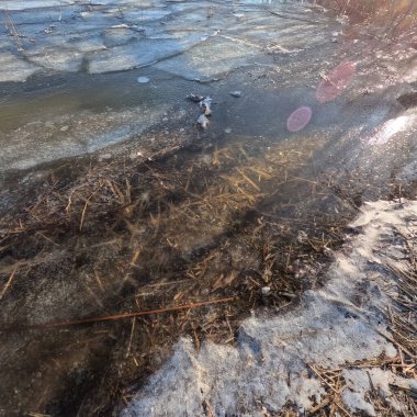 clear ice on the river. ice texture. the ice is melting. spring thaw. frozen water. air and water.