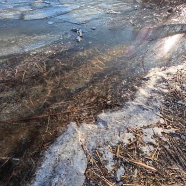 clear ice on the river. ice texture. the ice is melting. spring thaw. frozen water. air and water.