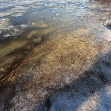 clear ice on the river. ice texture. the ice is melting. spring thaw. frozen water. air and water.