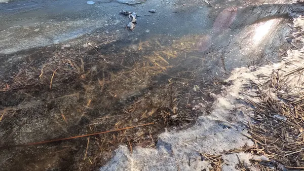 clear ice on the river. ice texture. the ice is melting. spring thaw. frozen water. air and water.